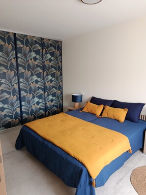 A bedroom with a bed, a nightstand, and a wall with a leaf pattern. - THE LITTLE HOUSE AND ITS SWIMMING POOL (Gourdan-Polignan)