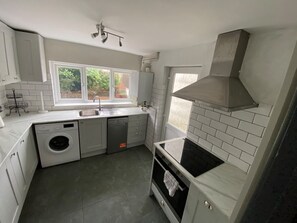Eine kleine Küche mit Waschmaschine, Geschirrspüler und Herd.