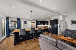 A modern living space with a kitchen, dining area, and a sofa. - Silverwood Resort & events Barn  (Perth)