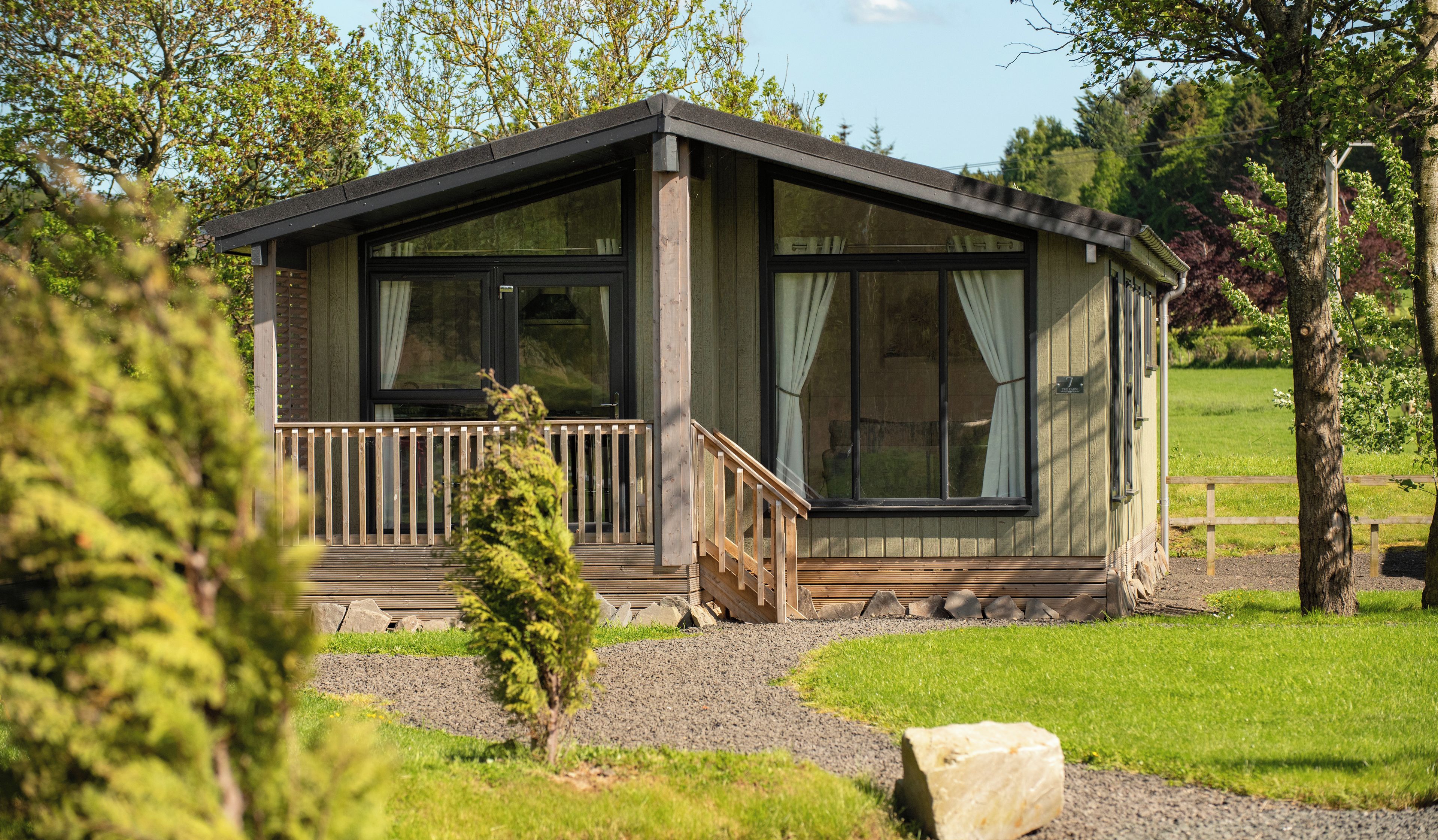 A small cabin with a wooden deck and a staircase leading to the entrance.