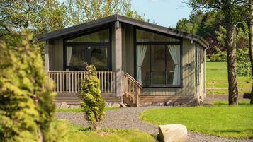 A small cabin with a wooden deck and a staircase leading to the entrance.