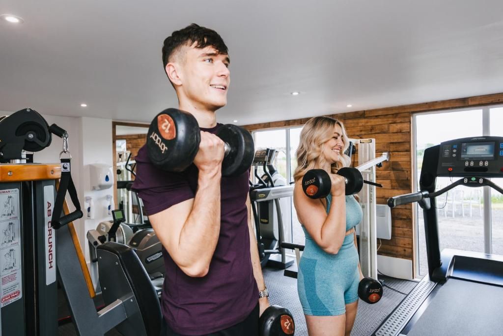 Een fitnessruimte met trainingsapparatuur, een loopband en een raam met uitzicht.