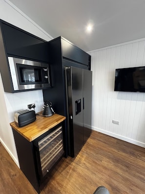 Cocina compacta con microondas, tostadora, hervidor y refrigerador.