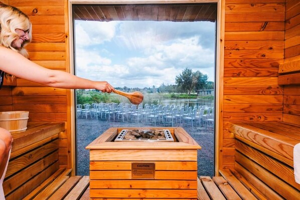 A sauna room with wooden walls, a bench, and a caution sign.
