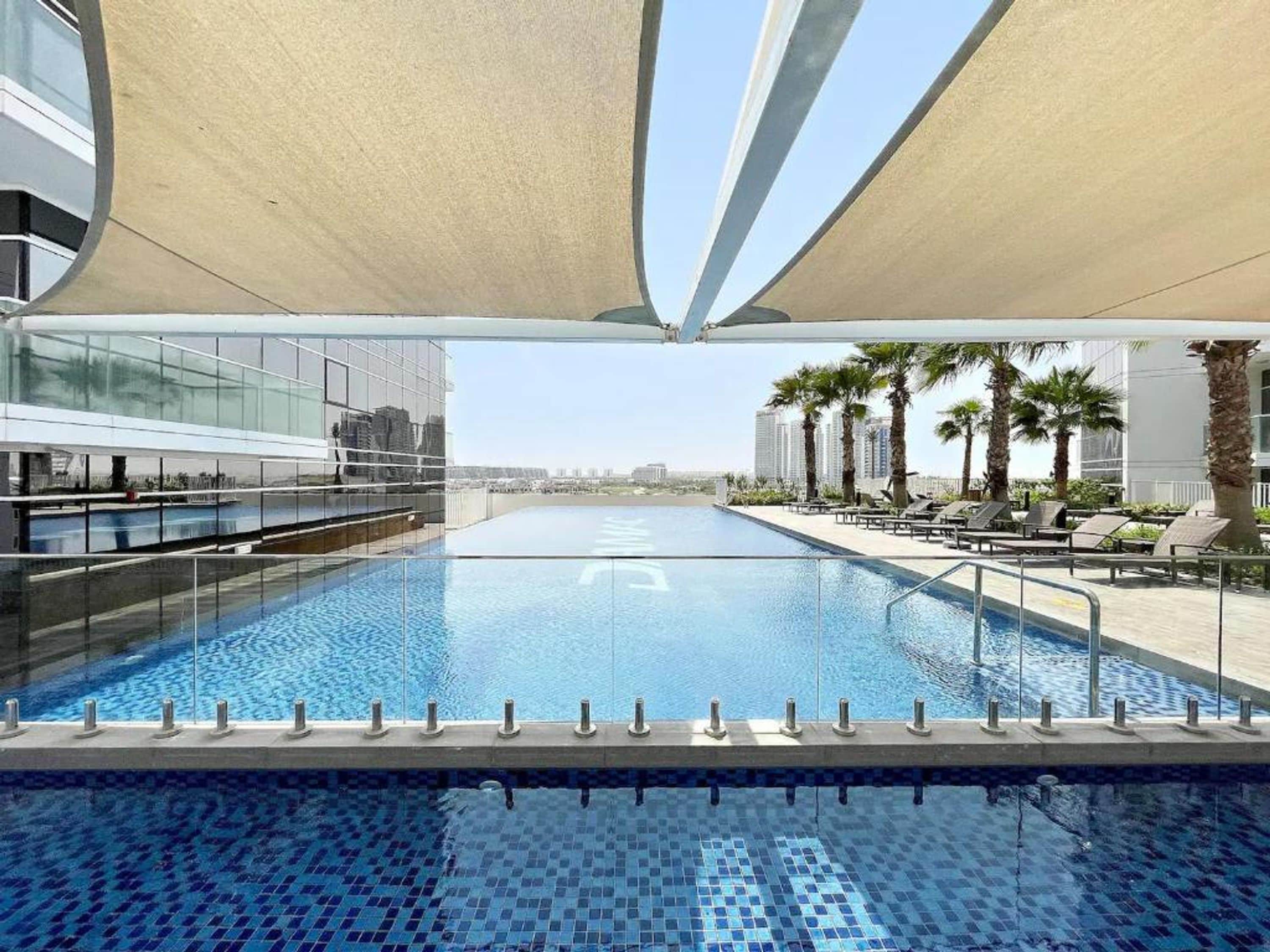 A swimming pool with a clear view of the city skyline in the background.