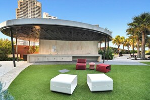 An outdoor seating area with a curved roof, a built-in bar, and a poolside view. - Jewel 27 Luxury 5 Star Beachfront King & Queen (Surfers Paradise)