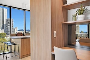 A modern kitchen with a large window, a coffee bar, and a dining area with a view of the cityscape. - Tranquillity at Encore 2BR Sea & Hinterland Views (Broadbeach)