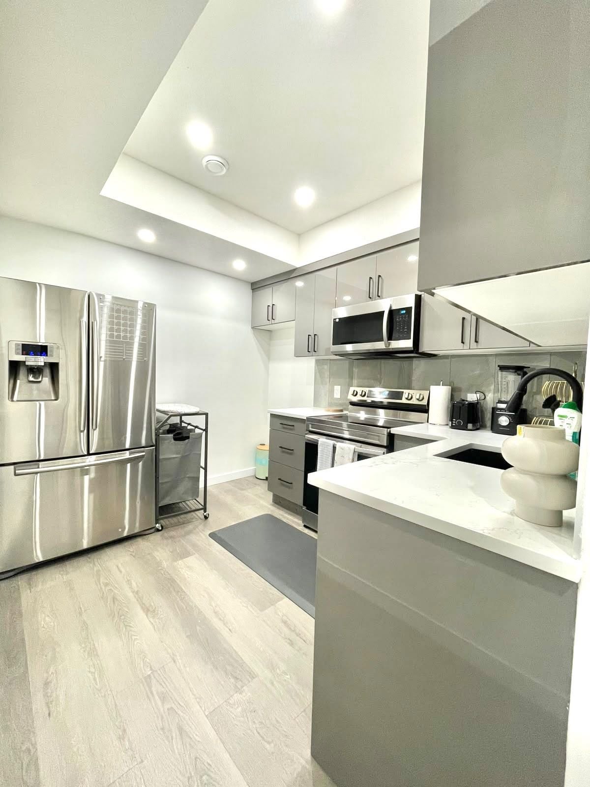 A modern kitchen with stainless steel appliances, a water dispenser, and a built-in microwave.