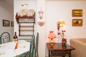 A dining area with a table set for six, a wine bottle, and a chair. - Apartment in Nerja Near Carabeillo Beach (Nerja)