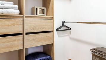 A walk-in closet with wooden shelving, a hanging rod, and a storage basket.