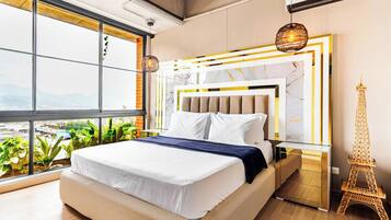 Un dormitorio moderno con una cama grande, una mesita de noche, una decoración de la Torre Eiffel y vistas amplias a través de grandes ventanales.