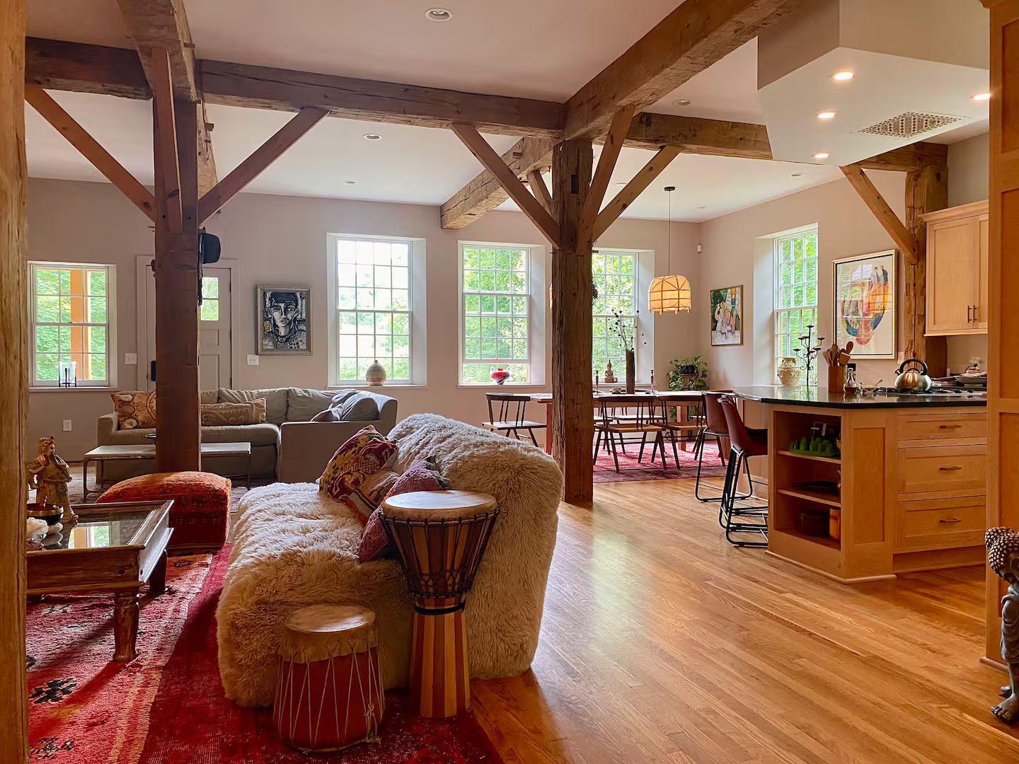 A spacious living area with a wooden ceiling, a dining area, and a kitchen with wooden cabinets.