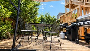 An outdoor patio with a table and chairs, a large umbrella, and a barbecue grill. - Gatsby’s OBP, 3rd House to the Beach, Heated Pool + 2 Hot Tubs, Sleeps 24 (Ocean Bay Park)
