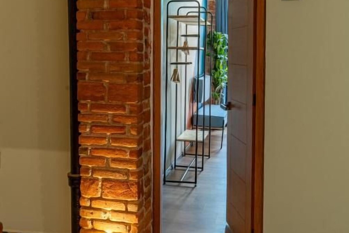 A hallway with a brick pillar, a tiled floor, and a door marked with the number 2.