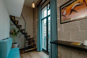A staircase with a potted plant, a framed artwork, and a window with curtains. - HOTEL TERRACOTA MX (Mexico City)