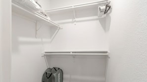 Ein weißer Schrank mit Kleiderstange und Schuhablage.