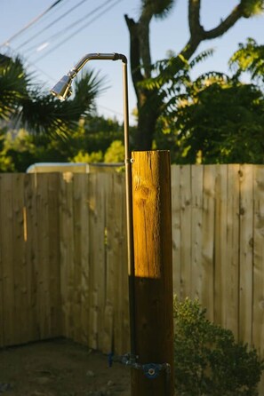 Un poteau en bois auquel est fixée une structure métallique, qui pourrait faire partie d’une clôture ou servir de support.