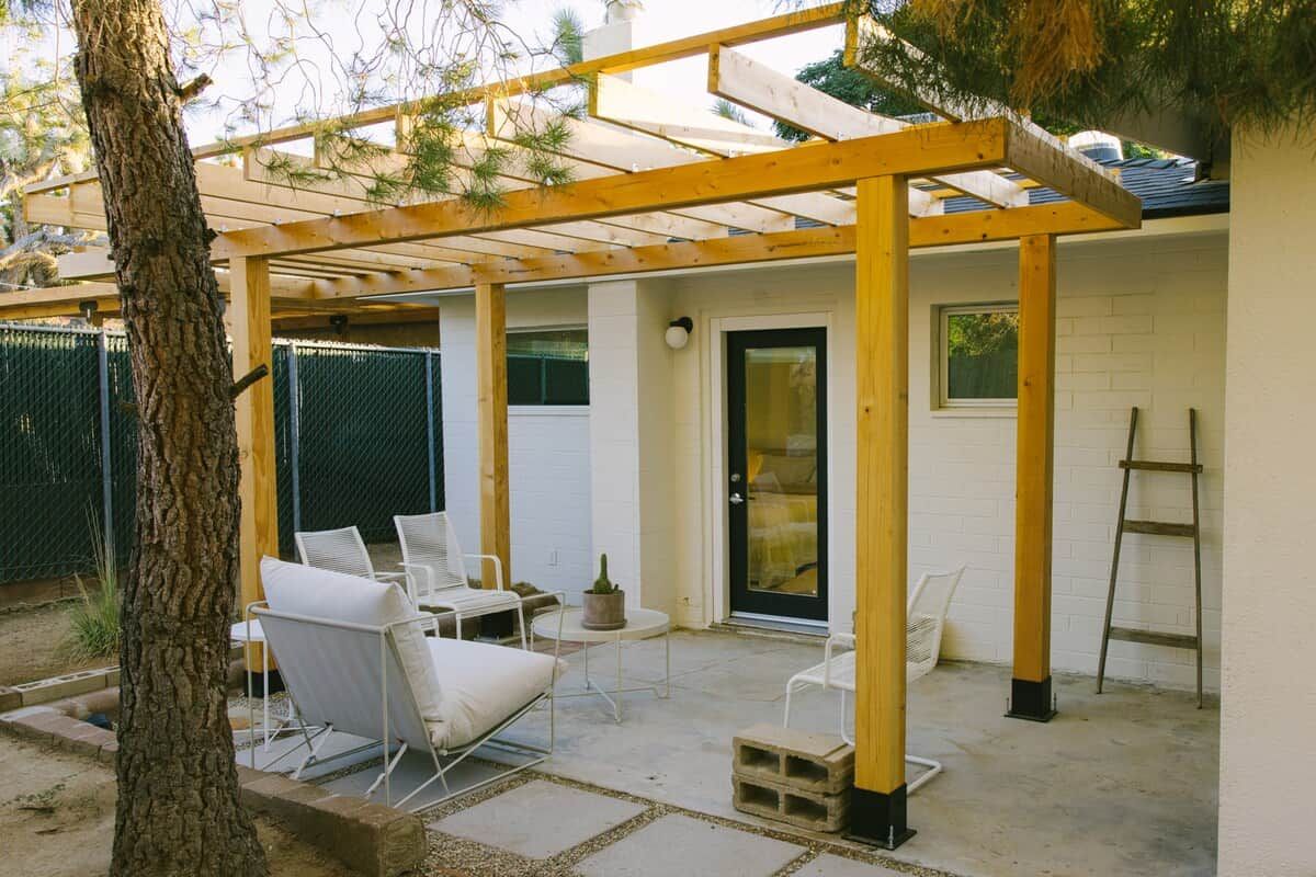 Un patio couvert avec des sièges d’extérieur, une porte et une échelle.