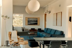 A modern living room with a sofa, chairs, a coffee table, and a dining table. - Quail Springs Ranch | Pool & Spa (Joshua Tree)