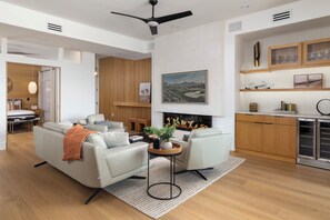 Een moderne woonkamer met een bank, een salontafel en een open haard.