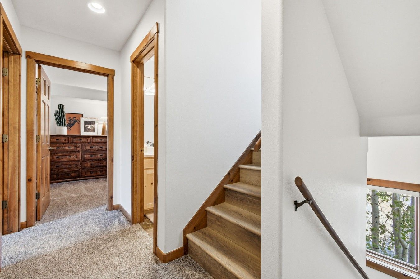 A hallway with wooden doors and a staircase leading to a bedroom.