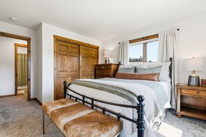 Ein Schlafzimmer mit einem Bett, einer Bank, einem Schminktisch und einem Kleiderschrank.