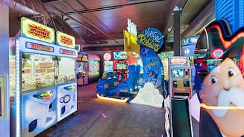 An indoor arcade with various gaming machines, including a 'Virtual Rabbids' ride and ticket machines.