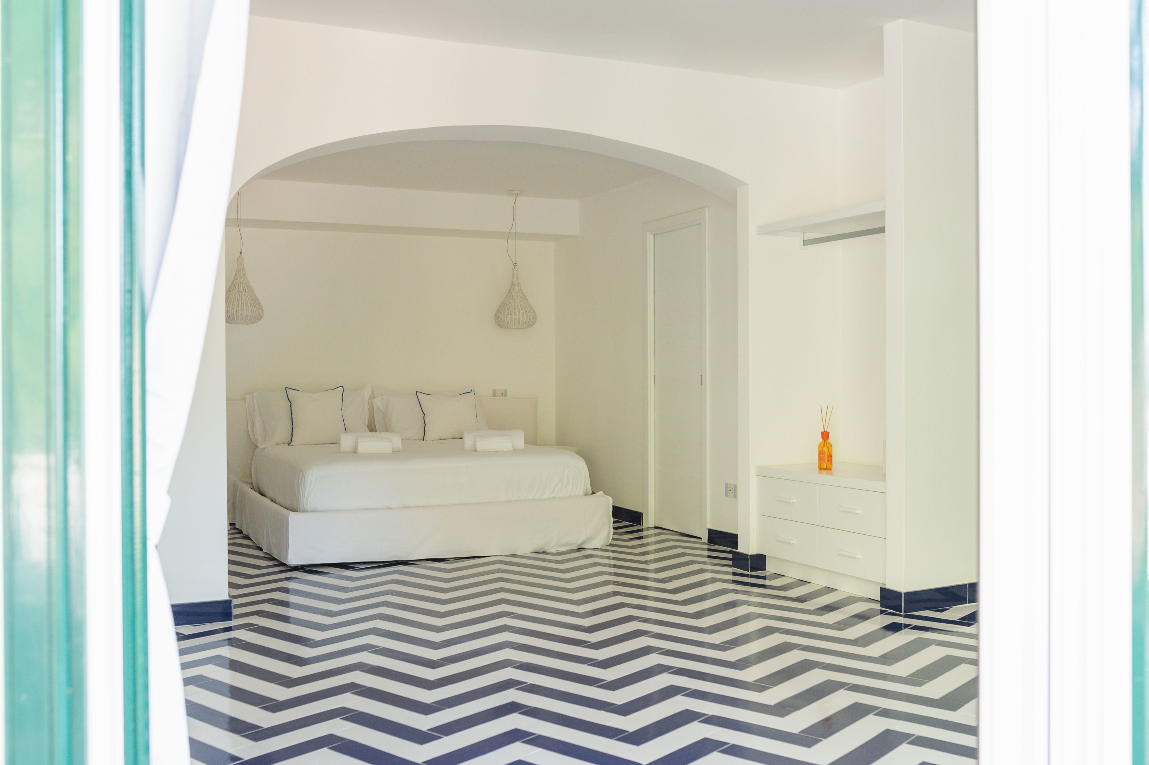 Una camera da letto con un letto, una cassettiera e uno specchio.