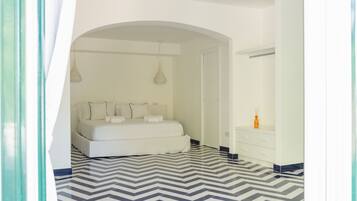 Una camera da letto con un letto, una cassettiera e uno specchio.