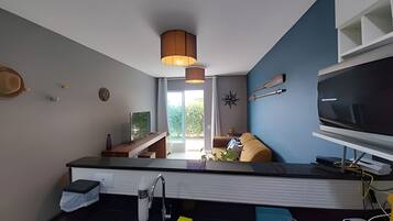 Cocina moderna con estufa integrada, lavaplatos y un televisor de pantalla plana grande.