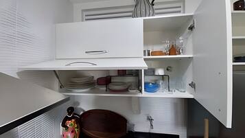A kitchen with white cabinets, a sink, and a decorative vase.