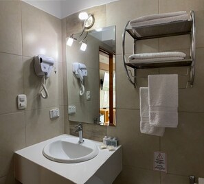 A bathroom with a sink, a mirror, a towel rack, and a hairdryer. - CELYMAR HOTEL (Viru)