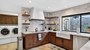 A modern kitchen with built-in appliances, wooden cabinetry, and a large window with decorative tiles. - Casa Talavera by Avantstay Pool + Hot Tub + Fire Pit + BBQ Mins to Golf (Scottsdale)