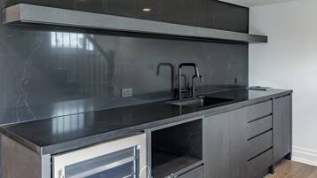 A modern kitchen with a sleek black countertop, stainless steel appliances, and a built-in oven.