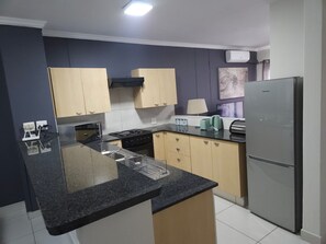 Cozinha moderna com uma ilha central, fogão e geladeira.
