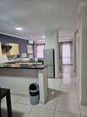 A modern kitchen with a central island, a built-in oven, and a refrigerator. - Sandton Westpoint Luxury Apartments 176 (Sandton)