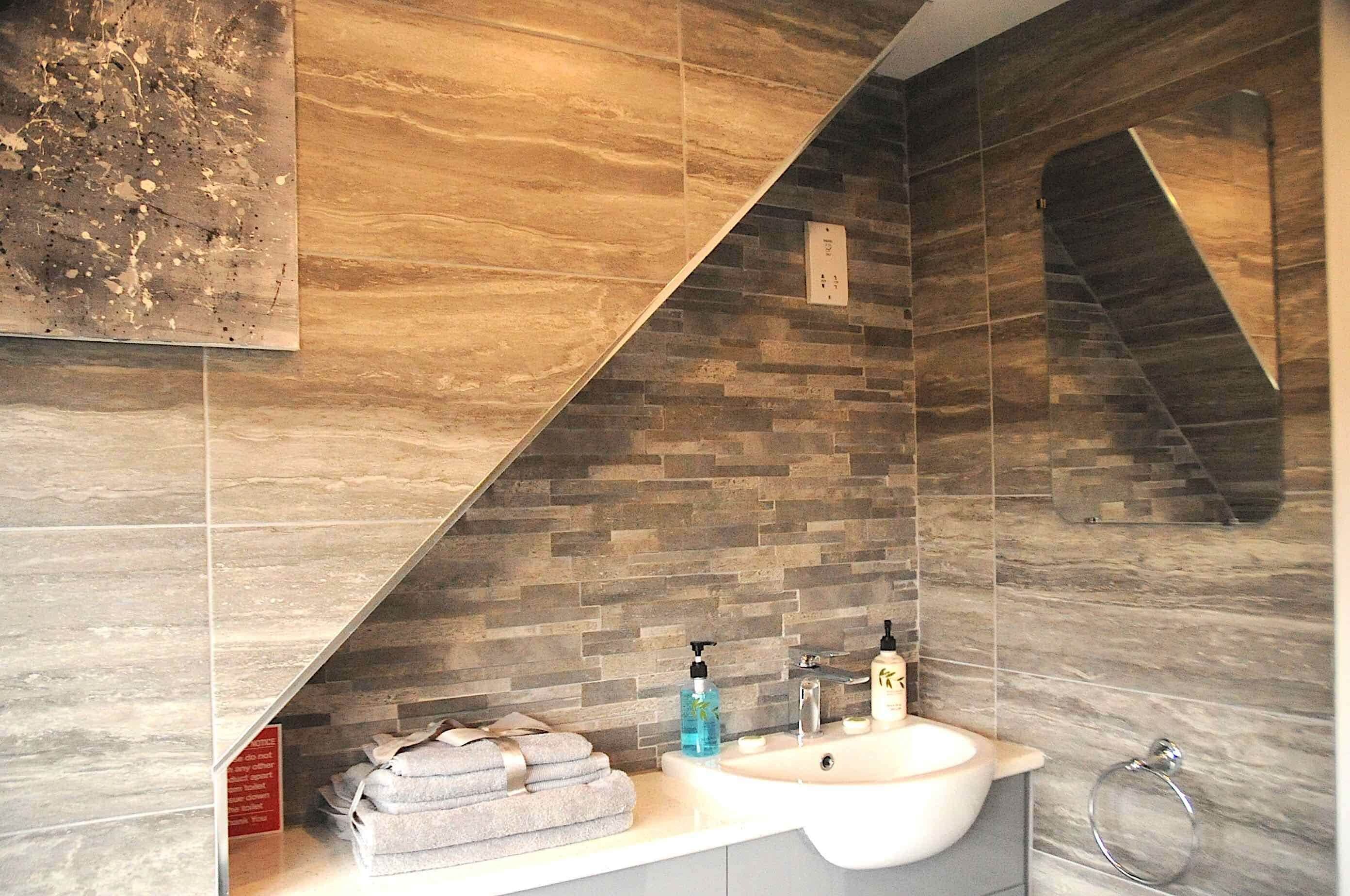 A bathroom with a dual sink, a mirror, and a towel rack.