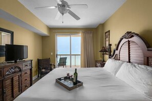 Ein Hotelzimmer mit Bett, Fernseher, Schreibtisch und einem Balkon mit Blick.