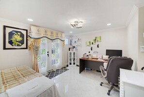 Een hotelkamer met een bed, een bureau, een stoel, een computer en een badkamer.