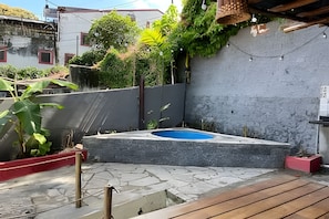 A concrete swimming pool with a wooden deck and a red planter. - Olinda sitio histórico - Loctemp (Olinda)