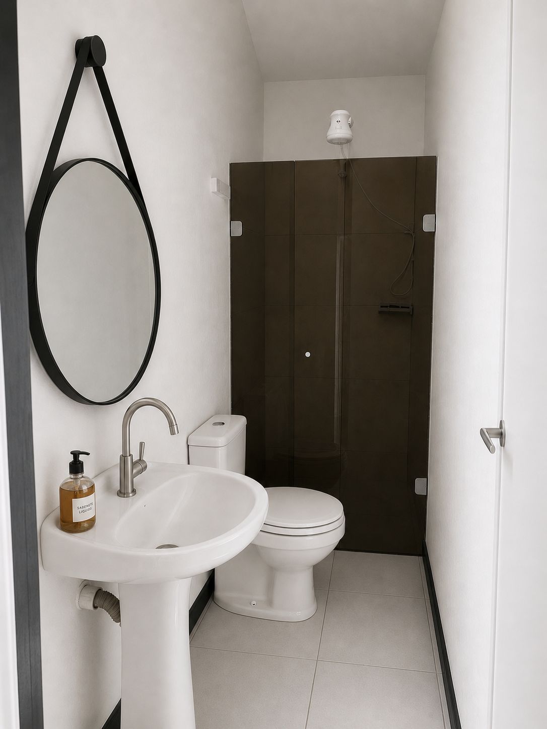 A bathroom with a white sink, a toilet, and a shower enclosure.