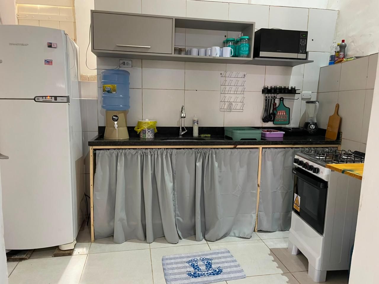 Cocina compacta con refrigerador, estufa y microondas.
