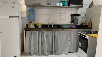 Cocina compacta con refrigerador, estufa y microondas.