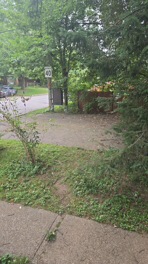 Eine Wohnstraße mit Geschwindigkeitsbegrenzung, einem geparkten Auto und einem Bürgersteig.
