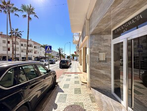 Straßenansicht mit einem Gebäude, auf dem 'EDIFICIO GAVIOTA 62' steht, und einem Fußgängerüberweg-Schild.