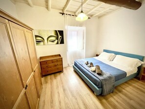 Ein Schlafzimmer mit einem Bett, einem Holzschrank und einem Bild an der Wand.