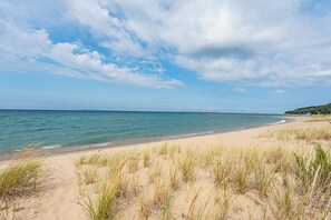 Ein Strand mit blauem Himmel und ruhigem Wasser.