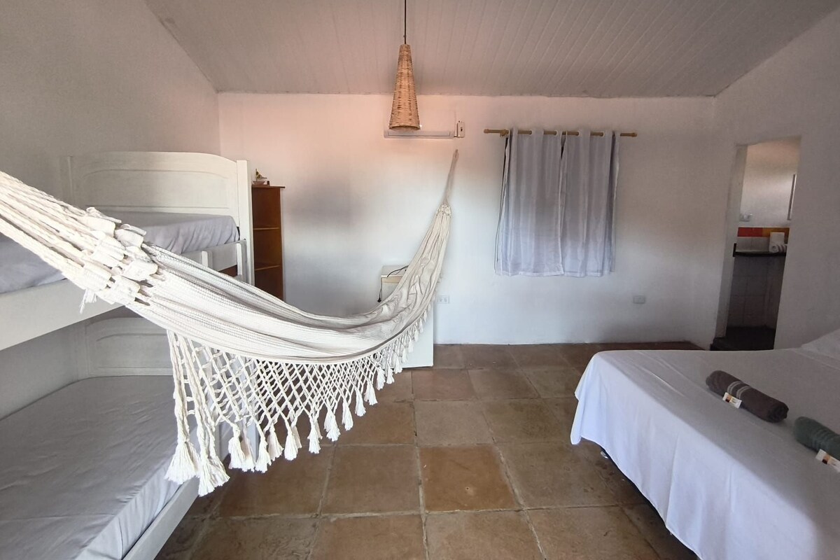 Ein Zimmer mit Hängematte, Etagenbett und einem Einzelbett.