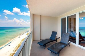 A balcony with two lounge chairs facing a beach and ocean view. - Ocean Reef 1702- Gulf of Grace (Panama City Beach)