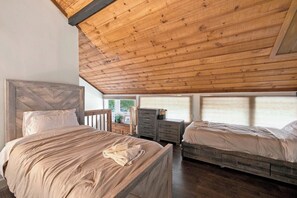 A bedroom with two beds, wooden headboard, a dresser, and a window with a view. - 3BR Mountain Home Near Loon Mountain (Lincoln)
